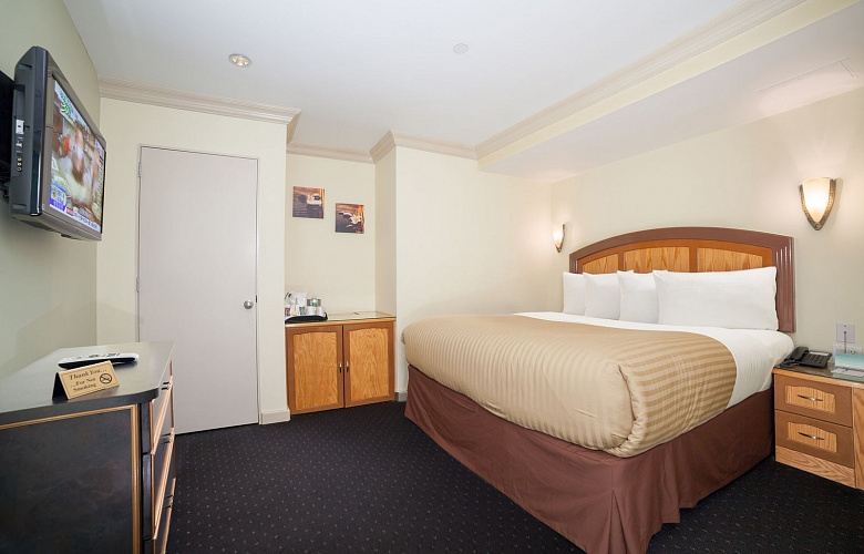 Photo 3 of Deluxe King Room with a king sized bed, view of the lower west side, and all the standard amenities.
